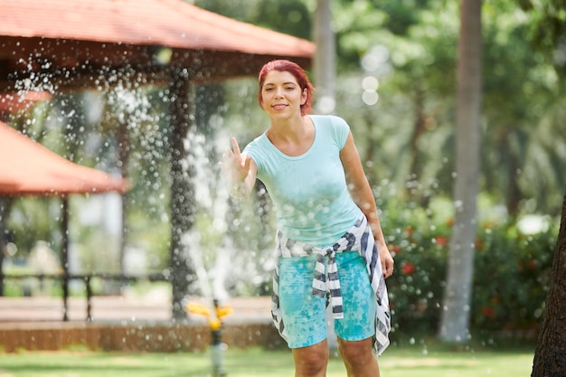 Donna allegra alla fontana del parco