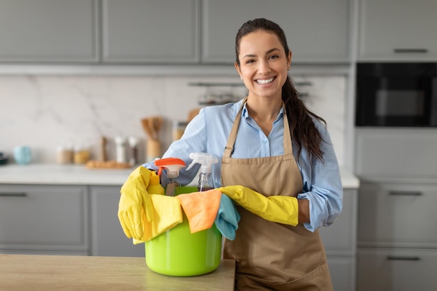 Donna allegra con prodotti per la pulizia pronti per i lavori domestici