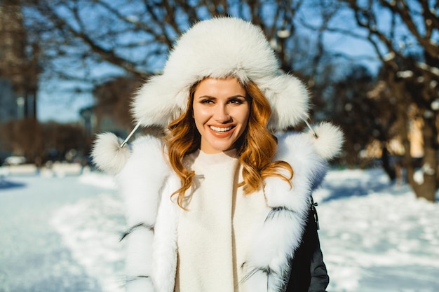 Donna allegra in cappotto e cappello di inverno all'aperto