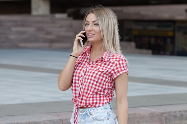 Donna allegra parlando al telefono per strada