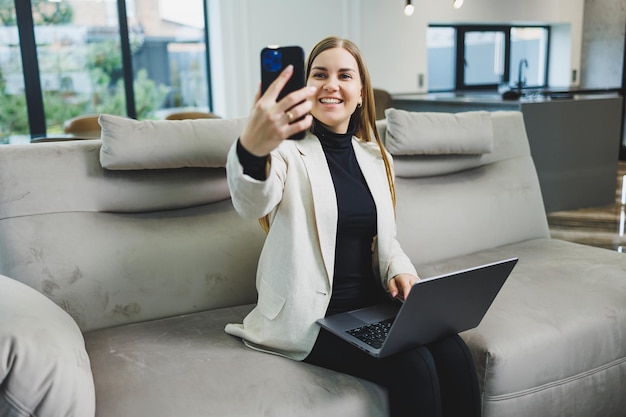 Donna allegra persona affascinante seduta dietro un netbook che guarda avere un buon umore lavorando a casa al chiuso Lavoro freelance remoto