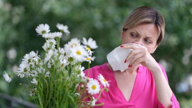 Donna allergica ai fiori primaverili selvatici e che tiene in mano il bouquet