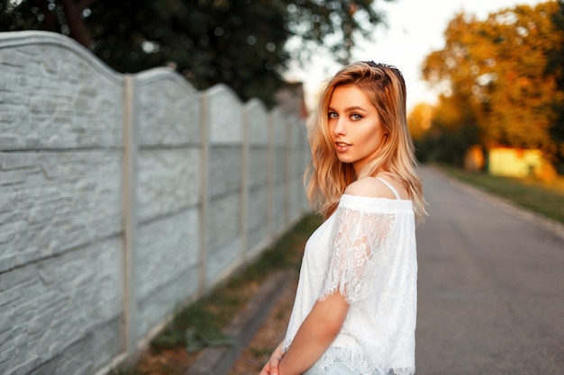 Donna americana felice abbastanza bionda in una maglietta vintage il giorno d'estate all'aperto