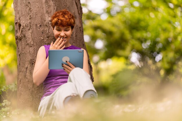 Donna androgina con tablet che ride dello scherzo