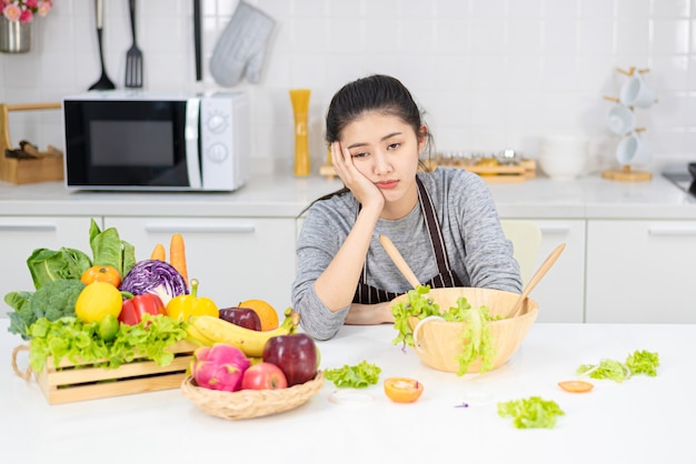 Donna annoiata a cucinare frustrata e assonnata.