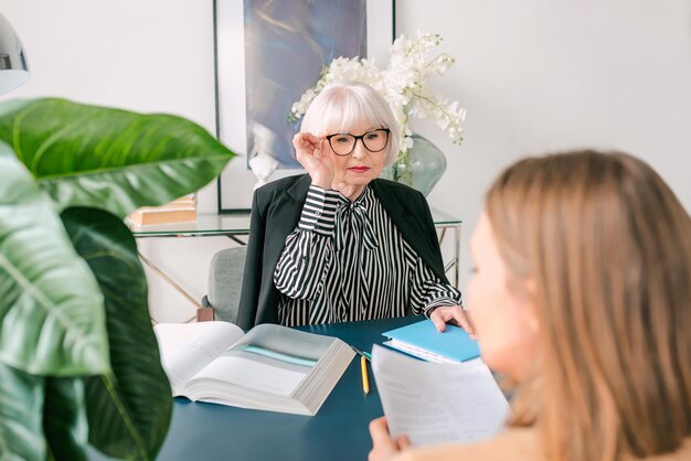 donna anziana alla moda con una giovane donna che discute le attività di lavoro in ufficio