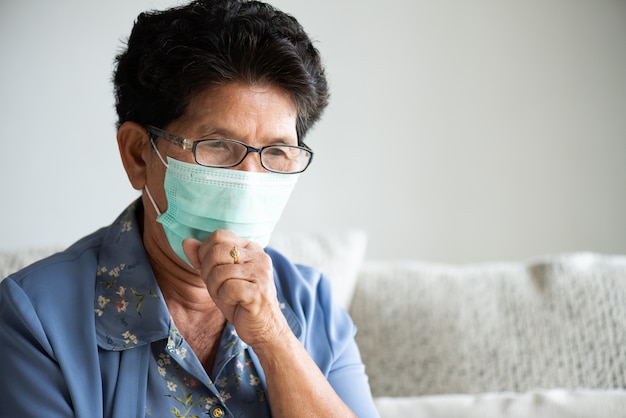 Donna anziana asiatica malata che indossa la maschera di protezione