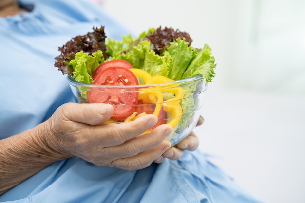 donna anziana asiatica paziente che mangia cibo sano di verdure a colazione