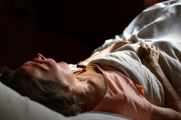 Donna anziana che dorme sul letto a casa