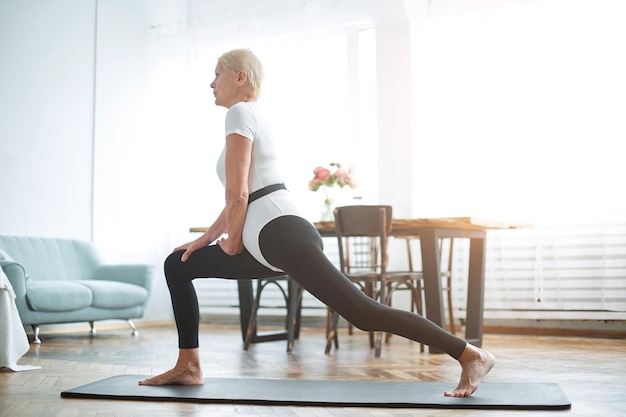 Donna anziana che esegue quotidianamente una foto di ginnastica per il benessere con un posto per il testo