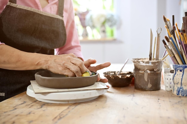 Donna anziana che fa una ceramica nelle attività e negli hobby del laboratorio artigianale