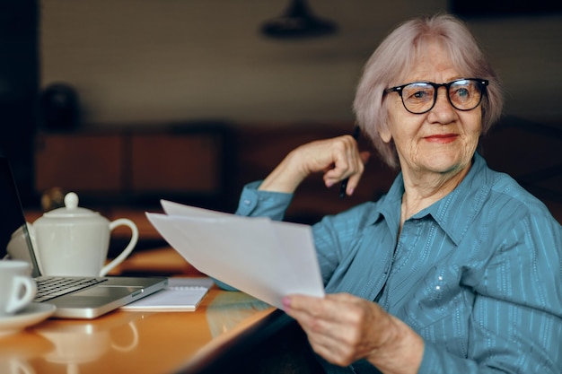 Donna anziana che lavora davanti al monitor del laptop seduto Stile di vita inalterato