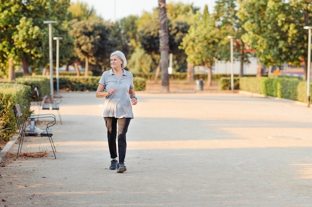 Donna anziana che pratica sport in un parco all'aperto