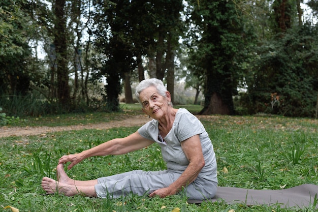 donna anziana che pratica yoga all&#39;aperto