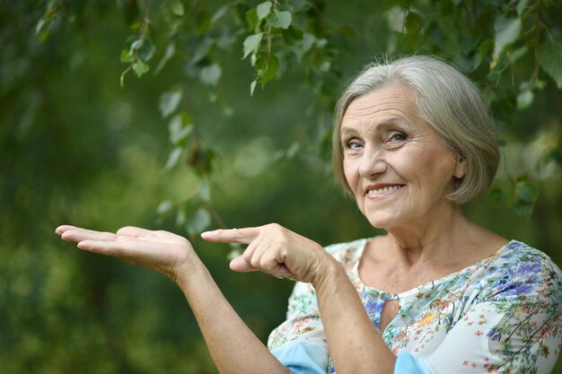 Donna anziana che punta su uno sfondo di natura