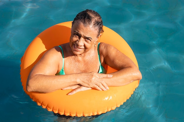 Donna anziana che si gode la vacanza nella piscina dell'hotel