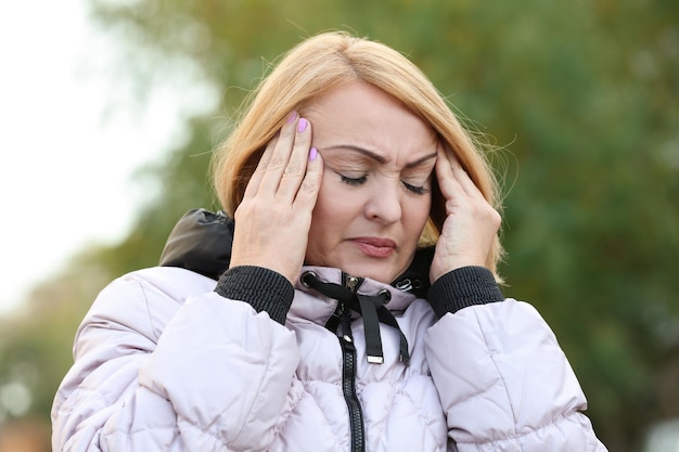 Donna anziana che soffre di mal di testa all'aperto