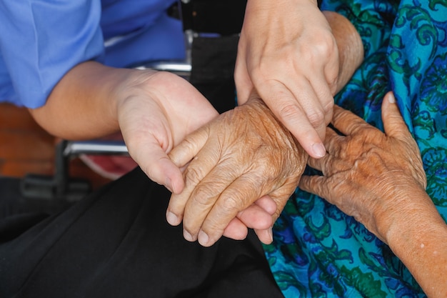 Donna anziana che tiene la mano con il caregiver