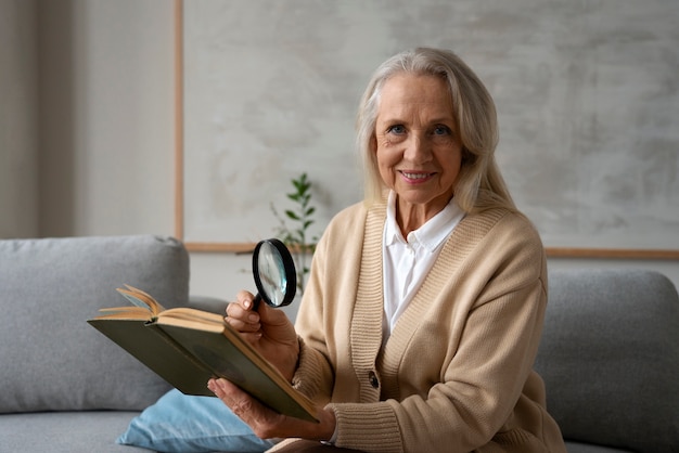 Donna anziana che usa una lente d'ingrandimento per leggere