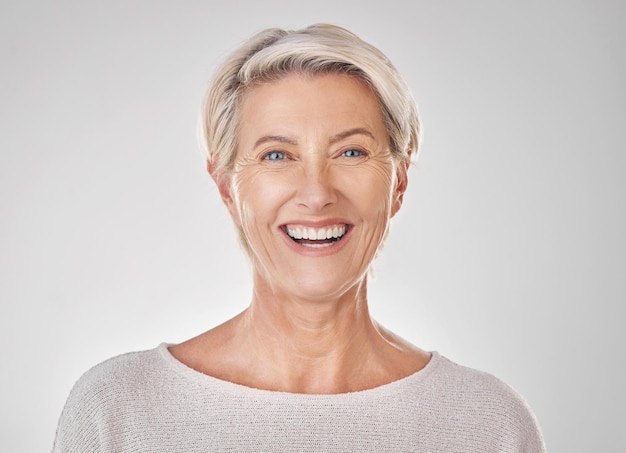 Donna anziana con il sorriso per la cura della pelle di bellezza della salute dentale e il viso contenuto su sfondo mockup di studio Ritratto di modello felice con denti sani trucco viso e benessere in pensione