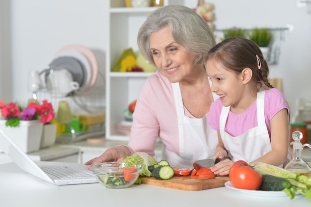 Donna anziana con la nipote che cucina in cucina