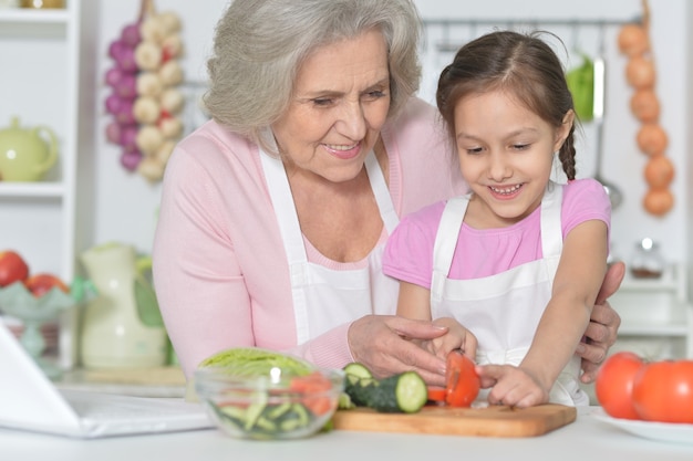 Donna anziana con la nipote che cucina in cucina