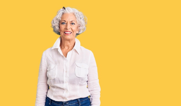 Donna anziana dai capelli grigi che indossa abiti casuali con un sorriso felice e fresco sul viso persona fortunata