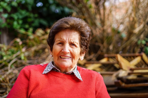 Donna anziana di 90 anni in giardino e ridendo con gioia.