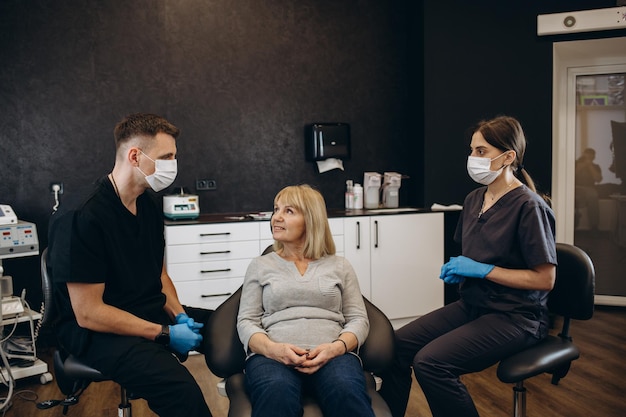 Donna anziana durante la visita medica con il dentista maschio nello studio dentistico