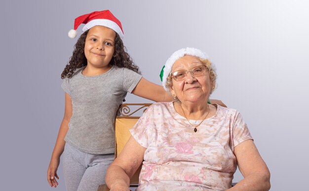 Donna anziana e bambino con cappello di Natale su grigio