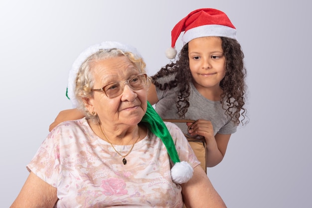 Donna anziana e bambino con cappello di Natale su grigio