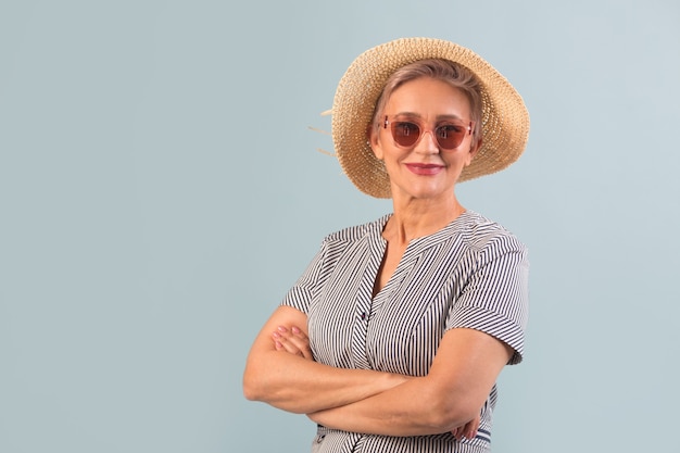 Donna anziana in un cappello su sfondo blu