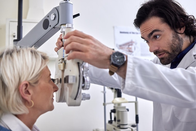 Donna anziana in un test della vista o esame della vista per la vista dal medico optometrista o oftalmologo con assistenza medica Paziente maturo in esame ottico per vedere o controllare il glaucoma con un utile ottico