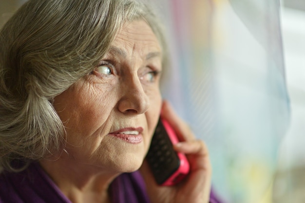 Donna anziana malata che chiama al telefono a casa