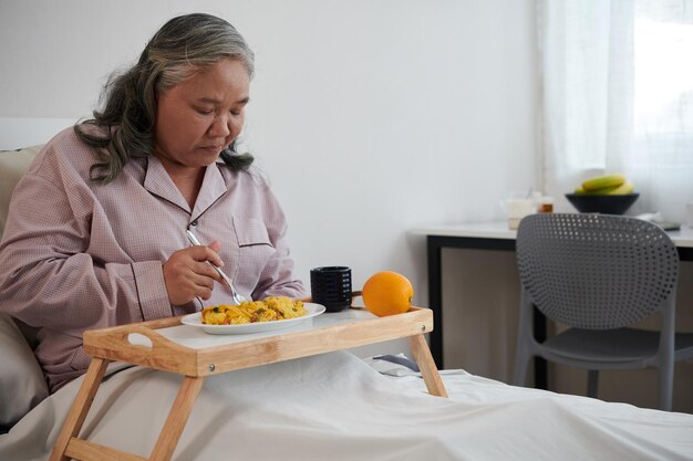 Donna anziana malata che mangia pranzo sano