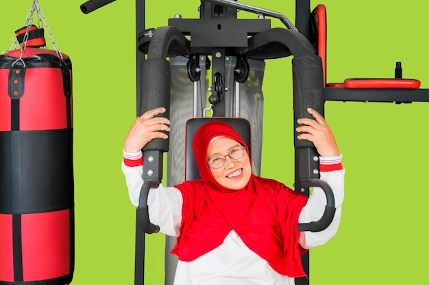 Donna anziana musulmana che fa allenamento sulla macchina da palestra
