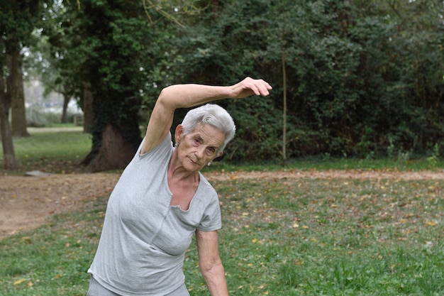 Donna anziana praticando yoga all&#39;aperto