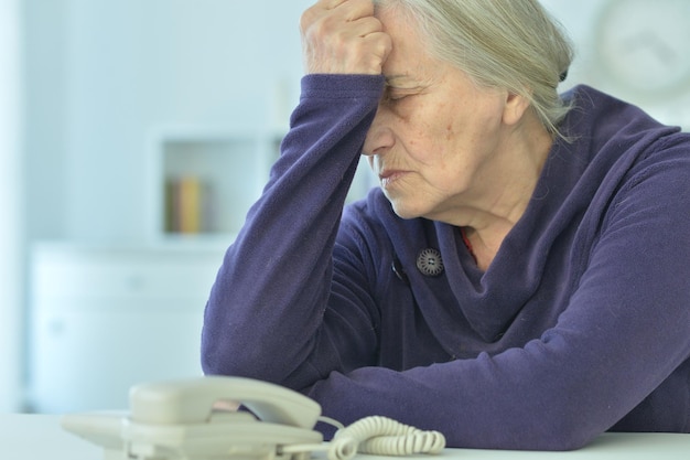 Donna anziana sconvolta con il telefono