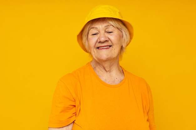 Donna anziana sorridente stile di vita felice in uno sfondo giallo copricapo giallo