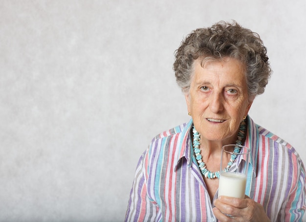 Donna anziana tra i 70 e gli 80 anni e un bicchiere di latte