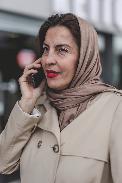 Donna araba con hijab parlando al telefono