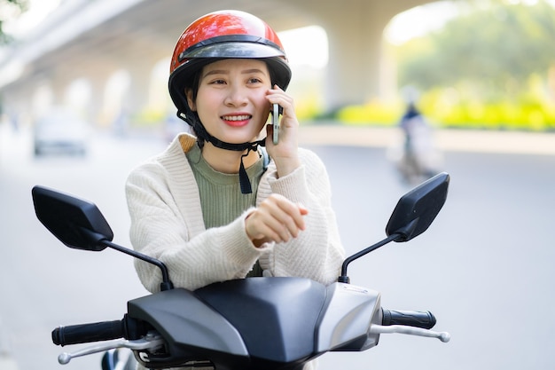 Donna asiatica alla guida di una moto mentre va al lavoro