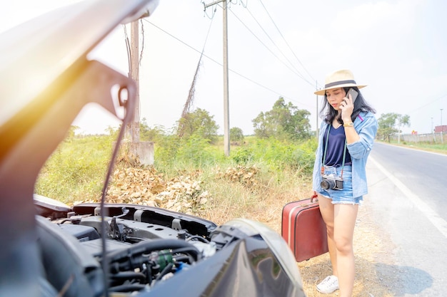 Donna asiatica carina Sta usando uno smartphone per chiedere aiuto Ha viaggiato e ha sperimentato l'intelligenza dell'auto fino a quando non ha dovuto chiedere aiuto