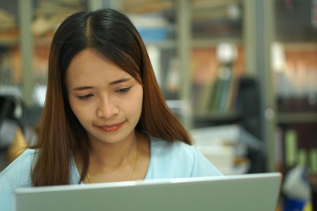 Donna asiatica che analizza il piano di lavoro del computer