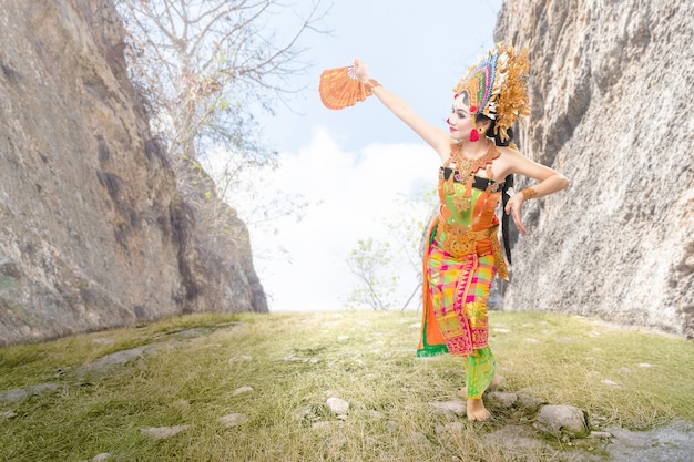 Donna asiatica che balla la danza tradizionale balinese (danza Kembang Girang) all'aperto