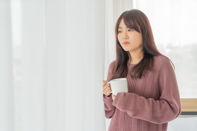 Donna asiatica che beve caffè al mattino