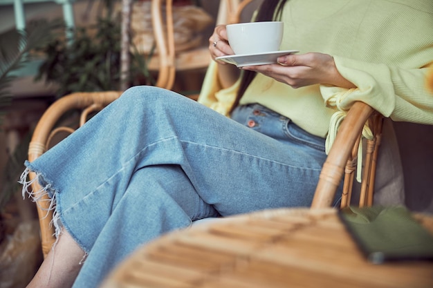 Donna asiatica che beve caffè e si rilassa in casa