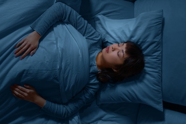 donna asiatica che dorme a letto a casa di notte