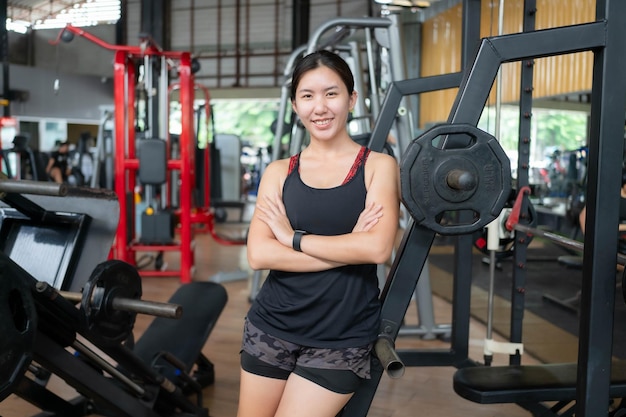 Donna asiatica che fa esercizio allenamento con i pesi in palestra concetto di fitness e cura della salute