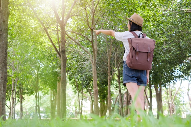 Donna asiatica che indica nell&#39;aforiforme dei campi di erba all&#39;aperto.